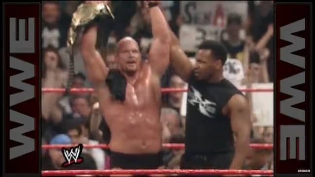 Mike Tyson raises Stone Cold Steve Austin's arm aloft after helping him to victory. Image: WWE.com