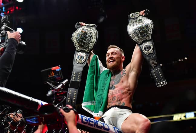 Conor McGregor with his two titles. Image: PA Images