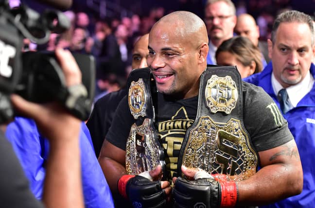 Daniel Cormier pictured with his light heavyweight and heavyweight belts. Credit: PA