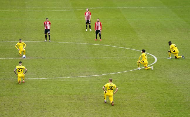 Brentford players stand whilst the Barnsley players take the knee. Image: PA Images