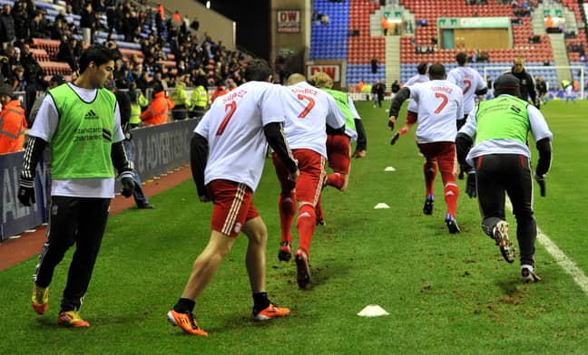 Liverpool players wear t-shirts with the name of Luis Suarez on as they warm up before their Premier League match at the DW Stadium, Wigan. Image: PA