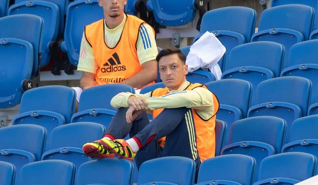 Ozil sat in the stands with no fans around. Image: PA Images