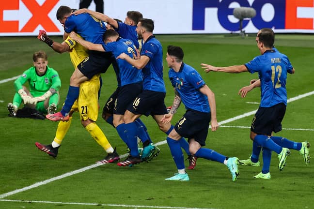 Italy players celebrate with their hero. Image: PA Images